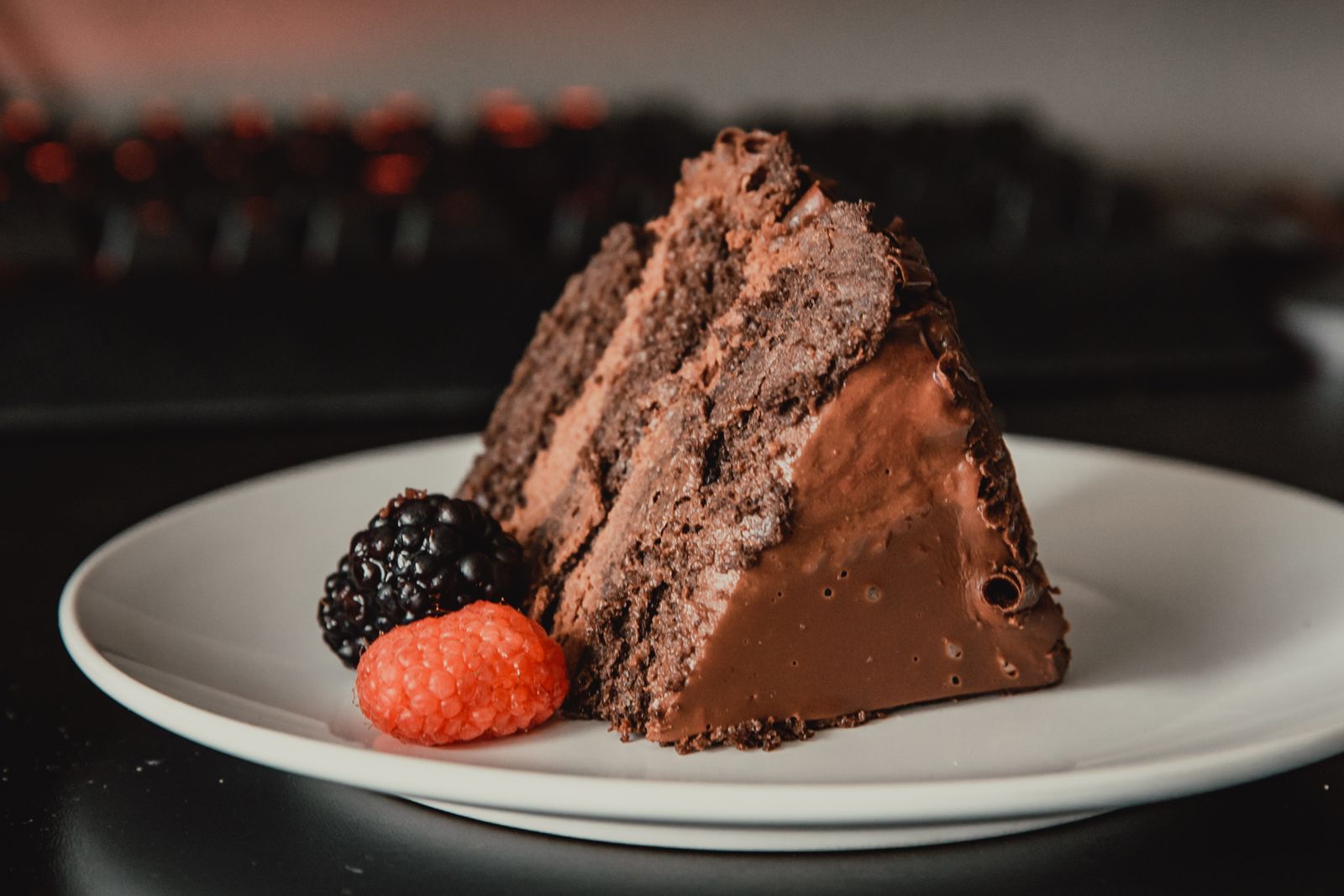 Part de gâteau au chocolat fondant accompagnée de fruits rouges