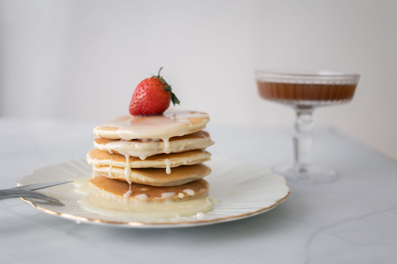 Pile de pancakes moelleux arrosés de sirop dans une assiette